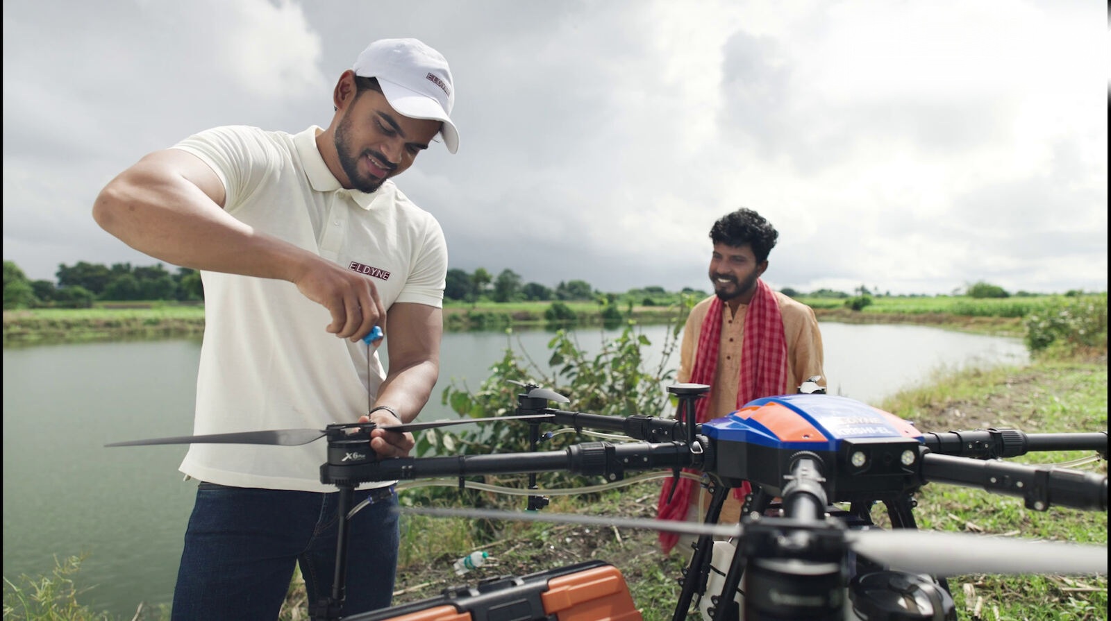 Two operators preparing the drone at the edge of a field
