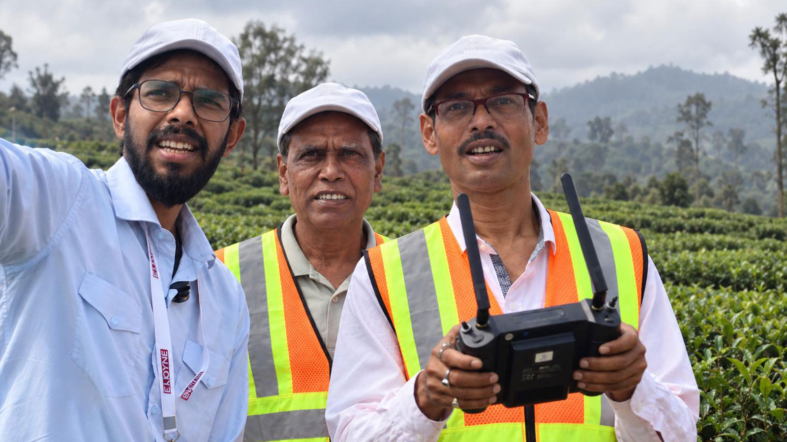 Two pilots watching the drone, one holding the controller